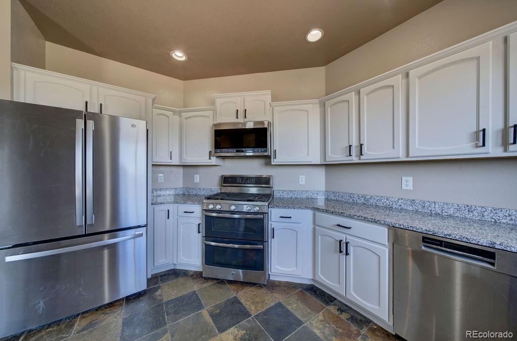14965 Tanner Trail Elbert, CO 80106 - Photo 9 of 40 a kitchen with stainless steel appliances granite countertop a refrigerator stove and sink
