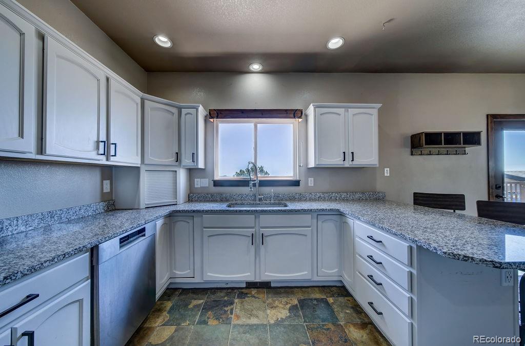 14965 Tanner Trail Elbert, CO 80106 - Photo 10 of 40 a kitchen with stainless steel appliances granite countertop a sink stove and cabinets