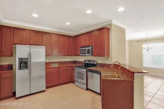 a kitchen with stainless steel appliances granite countertop a refrigerator stove a sink and dishwasher