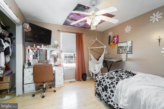 a bedroom with a bed a television and a large window