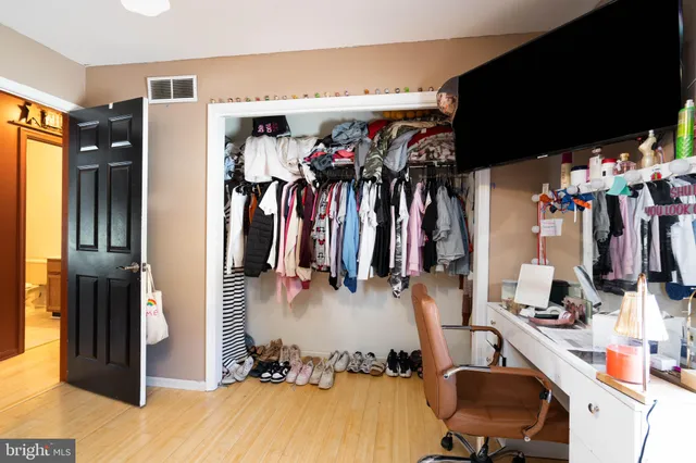 a view of walk in closet with clothes and shoes