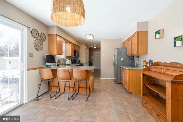 a kitchen with stainless steel appliances kitchen island granite countertop a stove a sink and a refrigerator