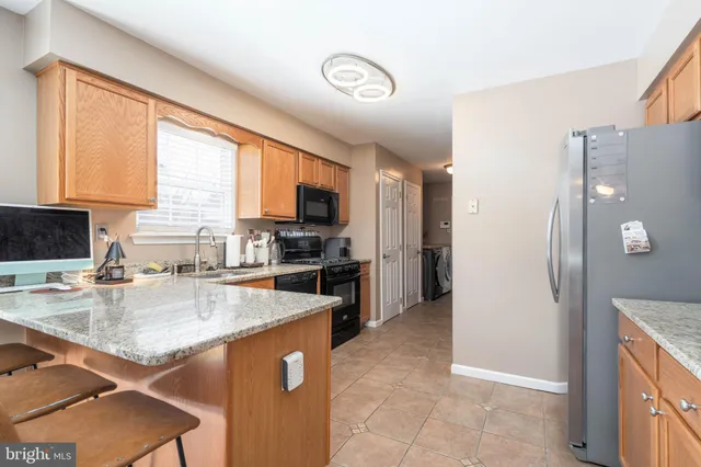 a kitchen with stainless steel appliances granite countertop a refrigerator a stove a sink a stove and island