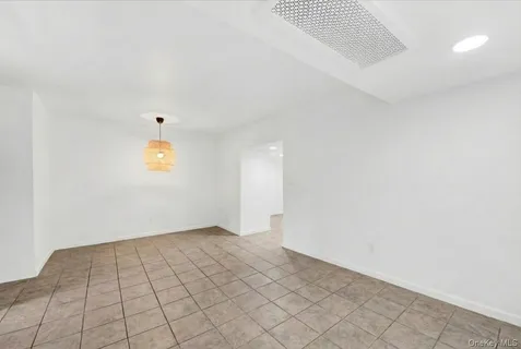 an empty room with a white wall and dryer