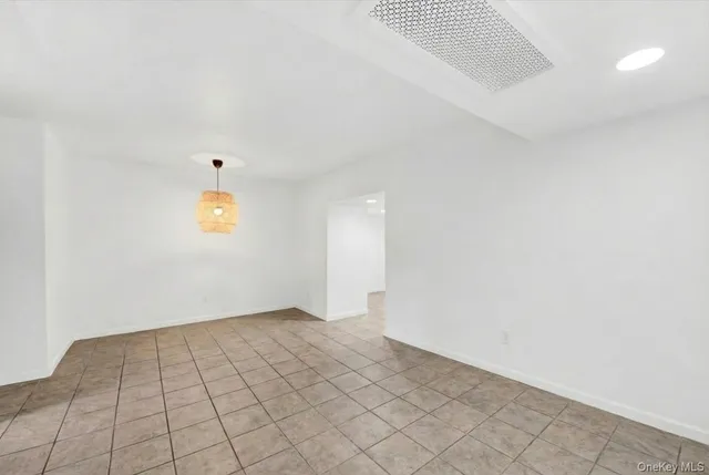 an empty room with a white wall and dryer