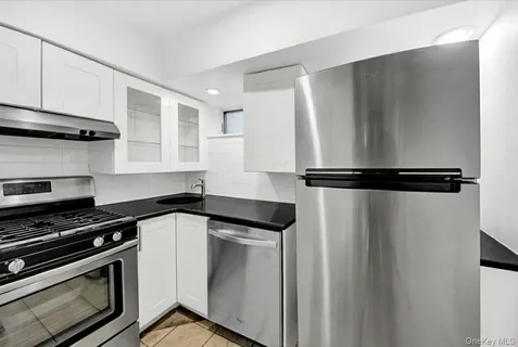 a kitchen with a refrigerator and a stove top oven