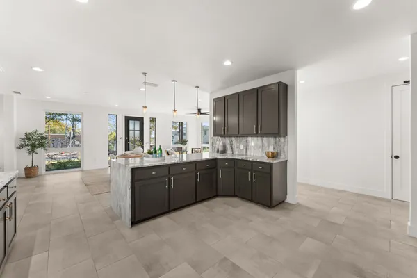 a large kitchen with kitchen island granite countertop a sink and cabinets