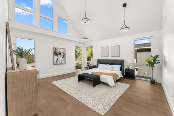a spacious bedroom with a large bed chandelier and a couch