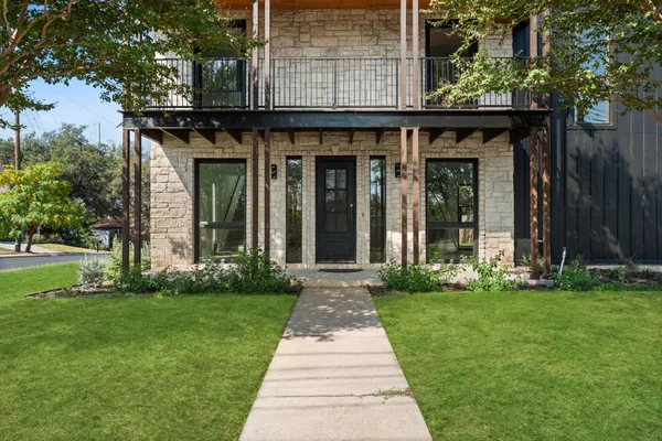 front view of a brick house with a yard