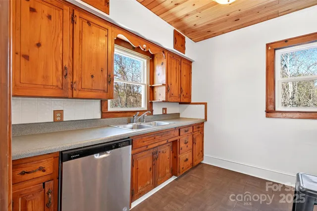 a kitchen with stainless steel appliances granite countertop a sink a stove cabinets and wooden floor