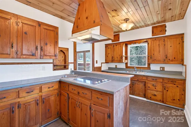 a kitchen with stainless steel appliances granite countertop a stove a sink dishwasher and cabinets with wooden floor