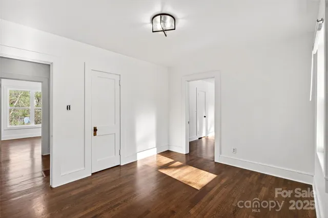 an empty room with wooden floor and window
