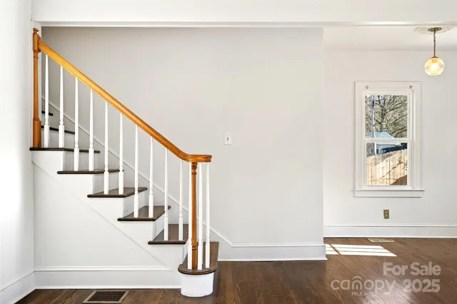 a view of entryway and hall with wooden floor