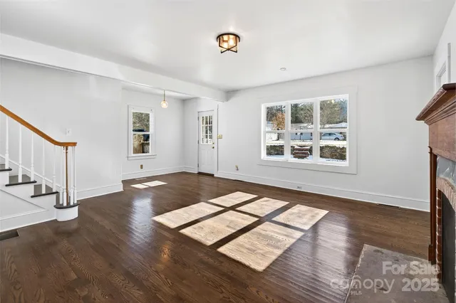 a view of an empty room window and wooden floor