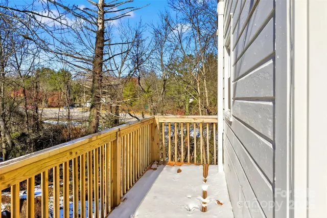 a view of a balcony with wooden floor and fence