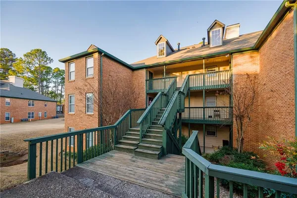a view of a house with large windows and a small yard
