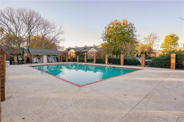 a view of a house with a yard and large trees