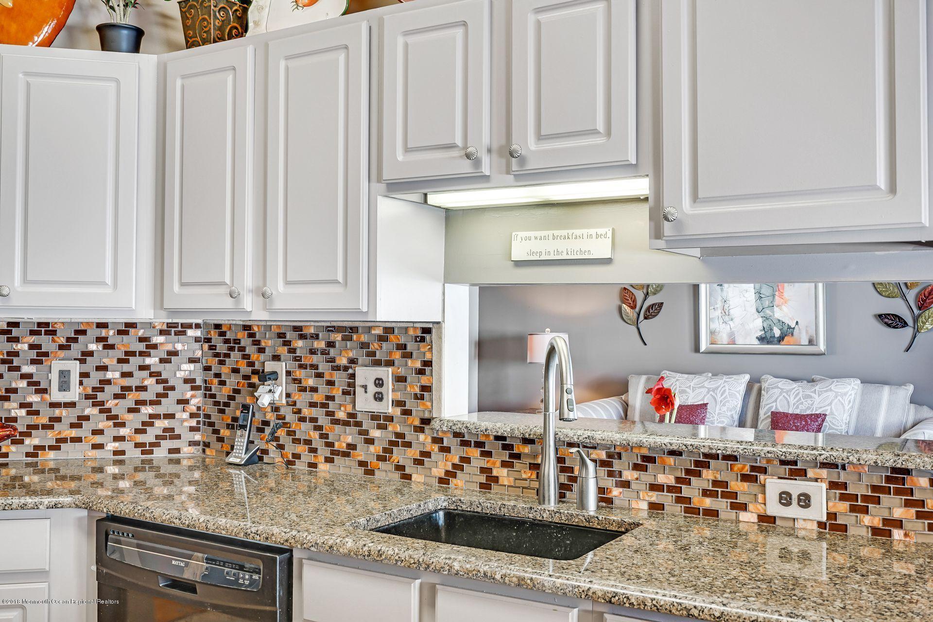 136 Cruise Road Manahawkin, NJ 08050 - Photo 17 of 34 a kitchen with white cabinets and wooden floor