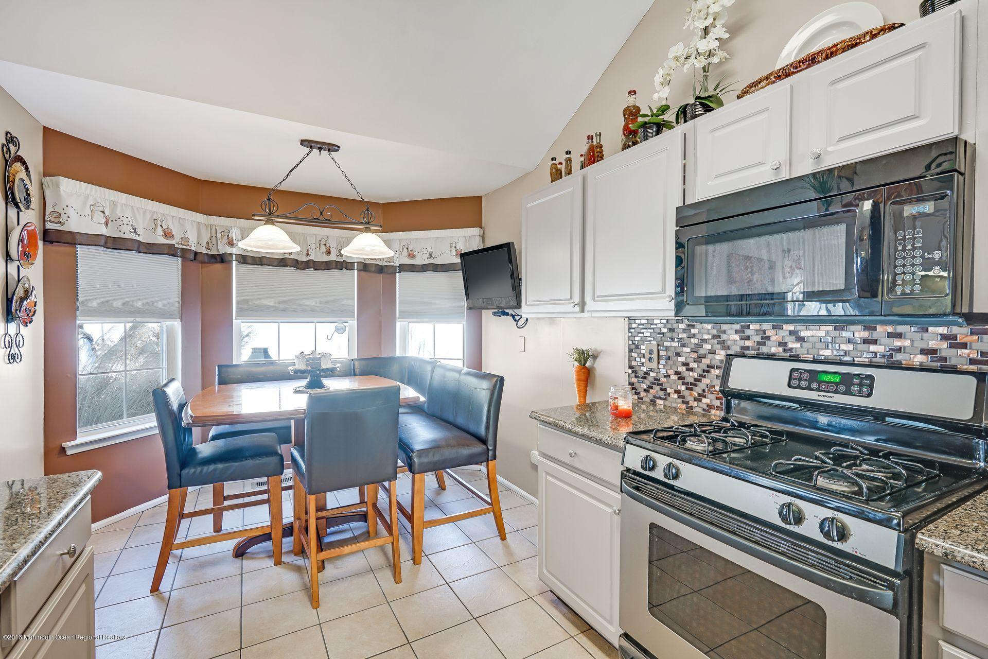 136 Cruise Road Manahawkin, NJ 08050 - Photo 21 of 34 a kitchen with stainless steel appliances a stove a sink cabinets and a dining table