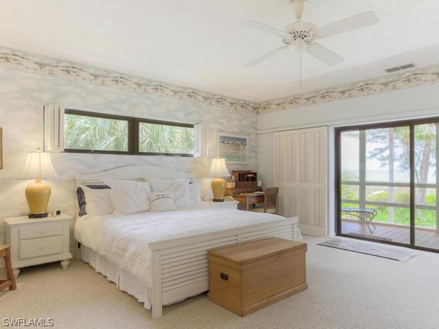 4627 Rue Belle Mer Sanibel, FL 33957 - Photo 11 of 25 a bedroom with a large bed and a chandelier fan