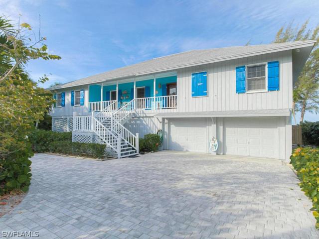 4627 Rue Belle Mer Sanibel, FL 33957 - Photo 6 of 25 a front view of a house with a garden and garage