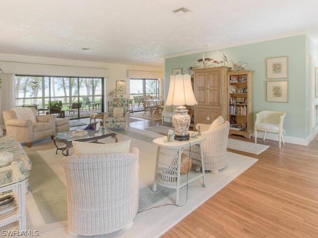 4627 Rue Belle Mer Sanibel, FL 33957 - Photo 7 of 25 a living room with furniture a large window and wooden floor