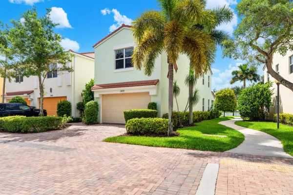 a front view of a house with a yard and a garage