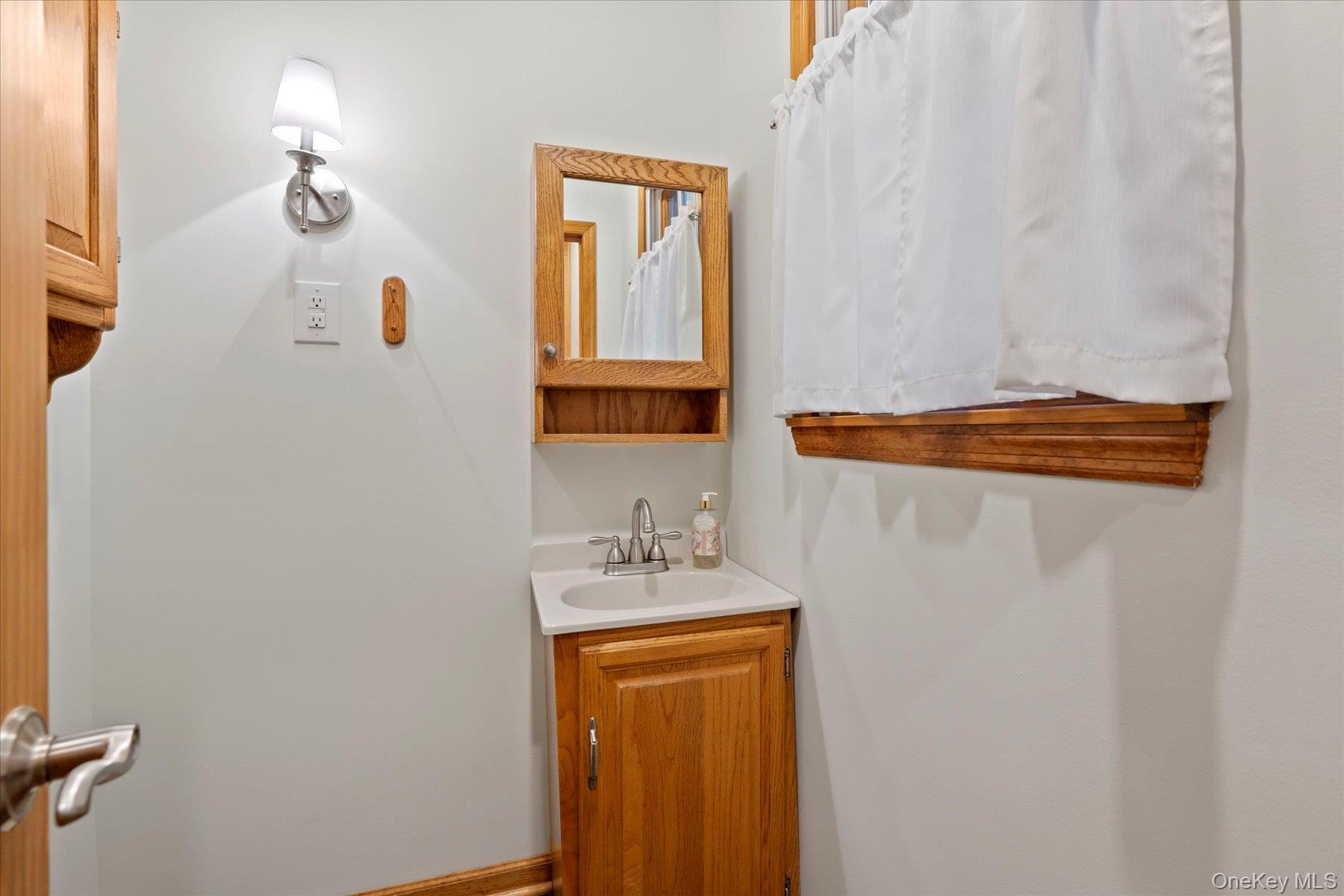51 Marvin Street Patchogue, NY 11772 - Photo 15 of 25 a bathroom with a sink a mirror and vanity