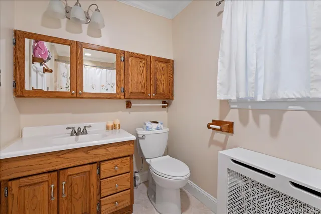 a bathroom with a sink a toilet and a window