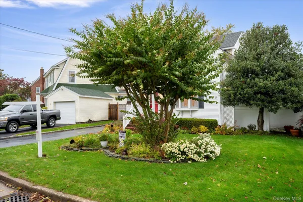 a garden with a bench in front of the house