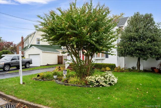a garden with a bench in front of the house