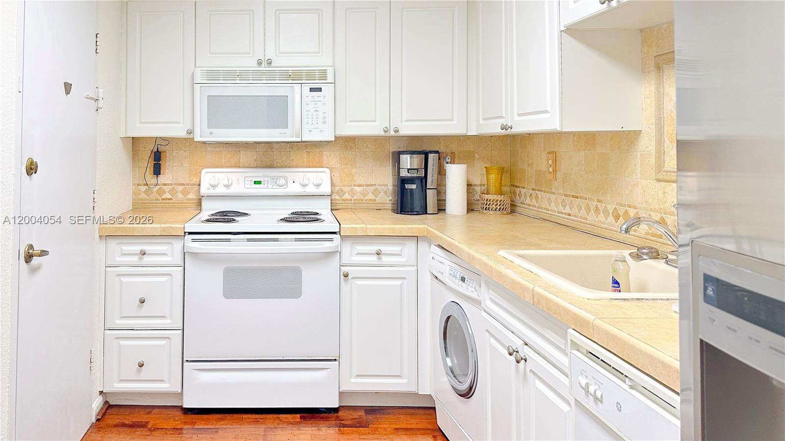 2501 South Ocean Drive, Unit 820 Hollywood, FL 33019 - Photo 8 of 12 a kitchen with granite countertop white cabinets and white appliances