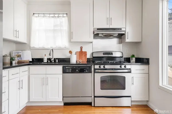 a kitchen with white cabinets and white appliances