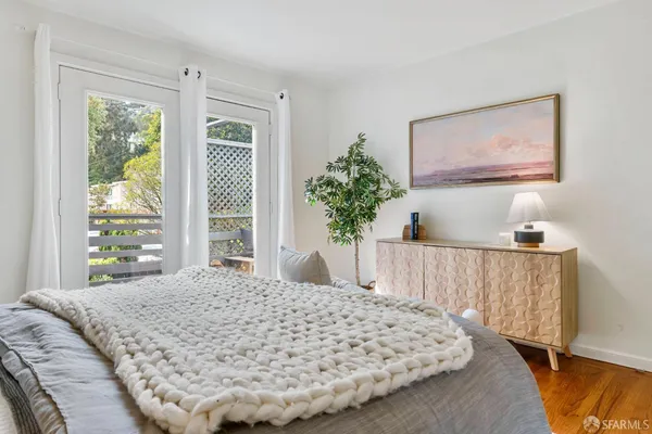 a bed sitting in a bedroom next to a window with potted plant