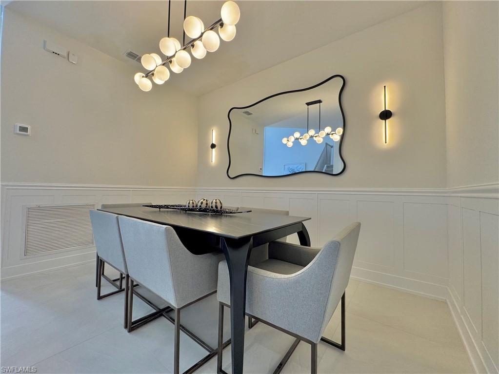 12667 Biscayne Court Naples, FL 34105 - Photo 12 of 39 a view of a dining room with furniture and a chandelier