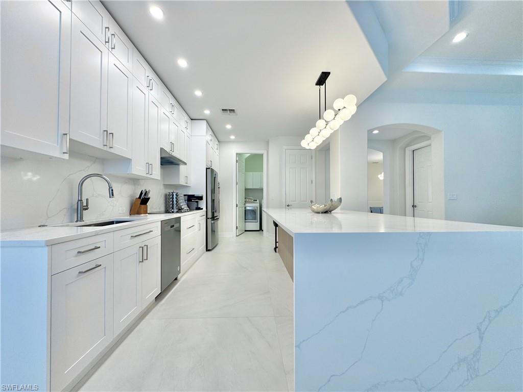 12667 Biscayne Court Naples, FL 34105 - Photo 15 of 39 a large kitchen with cabinets