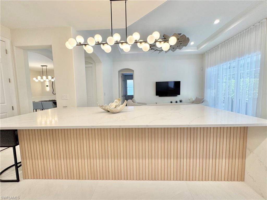 12667 Biscayne Court Naples, FL 34105 - Photo 18 of 39 a bedroom with a chandelier and a chandelier