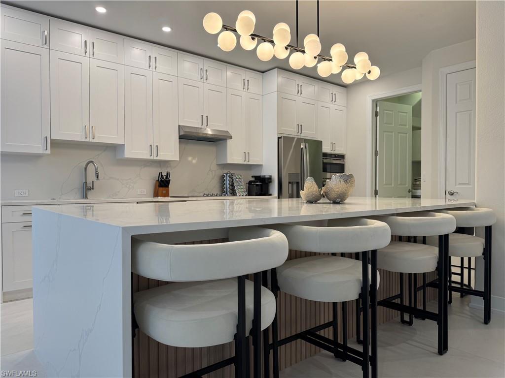 12667 Biscayne Court Naples, FL 34105 - Photo 21 of 39 a kitchen with a table and chairs in it