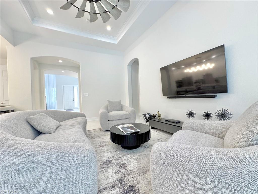 12667 Biscayne Court Naples, FL 34105 - Photo 24 of 39 a living room with furniture and a flat screen tv
