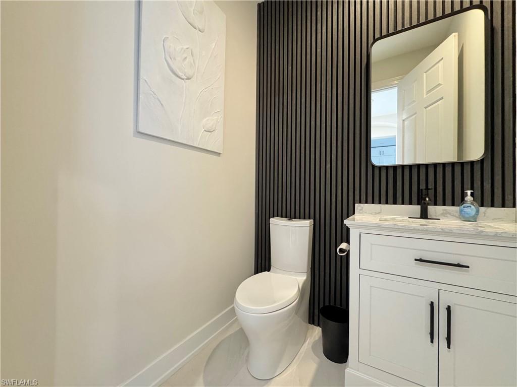 12667 Biscayne Court Naples, FL 34105 - Photo 27 of 39 a bathroom with a toilet a sink and a mirror