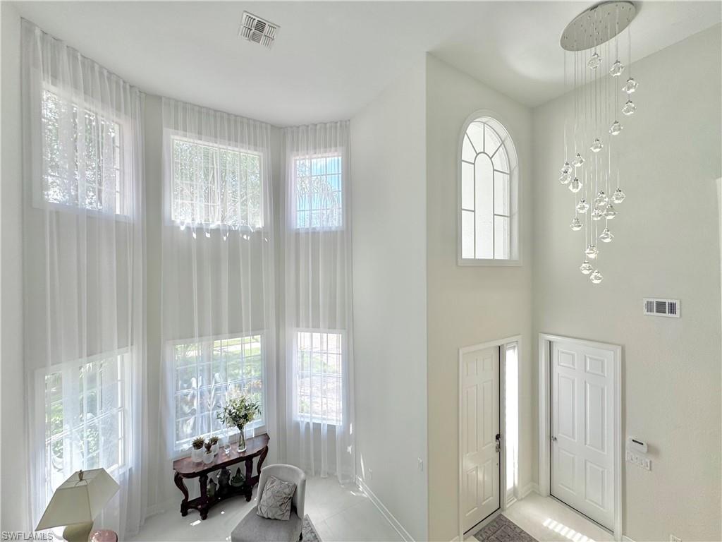 12667 Biscayne Court Naples, FL 34105 - Photo 5 of 39 a living room with furniture and a large window