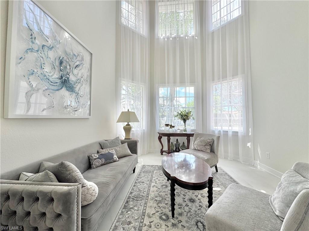 12667 Biscayne Court Naples, FL 34105 - Photo 7 of 39 a living room with furniture and a large window
