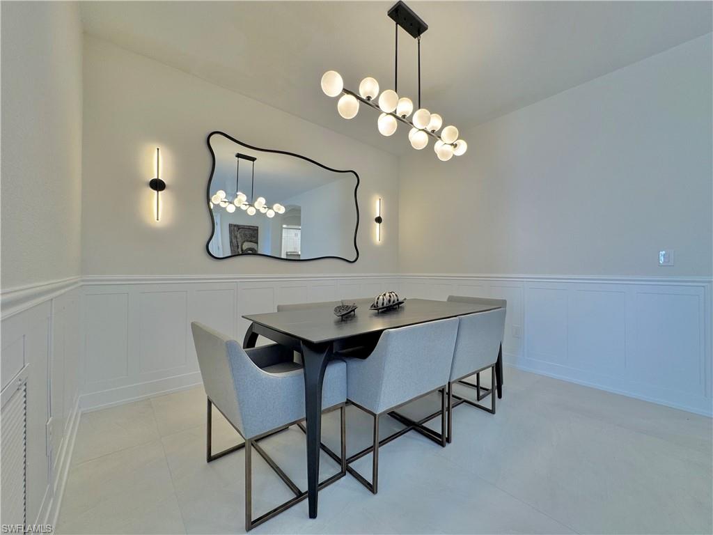 12667 Biscayne Court Naples, FL 34105 - Photo 8 of 39 a view of a dining room with furniture and chandelier