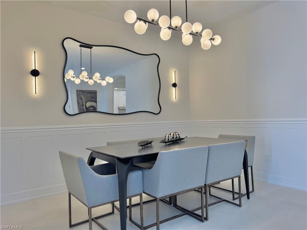 12667 Biscayne Court Naples, FL 34105 - Photo 10 of 39 a dining room with furniture and chandelier