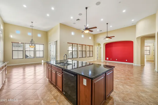 a kitchen with stainless steel appliances granite countertop a sink a stove and a wooden cabinets