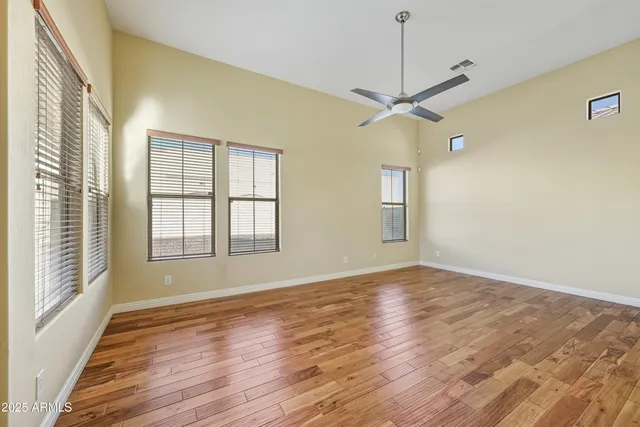 a view of an empty room with a window and wooden floor