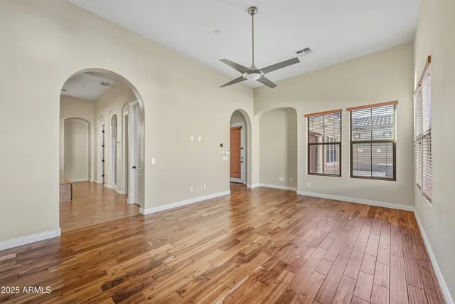 a view of an empty room with a window and wooden floor