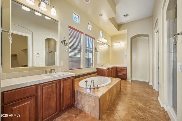 a bathroom with a granite countertop tub sink and mirror