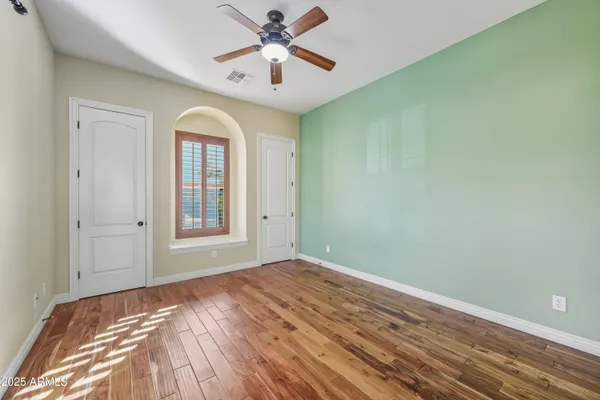 an empty room with windows and fan