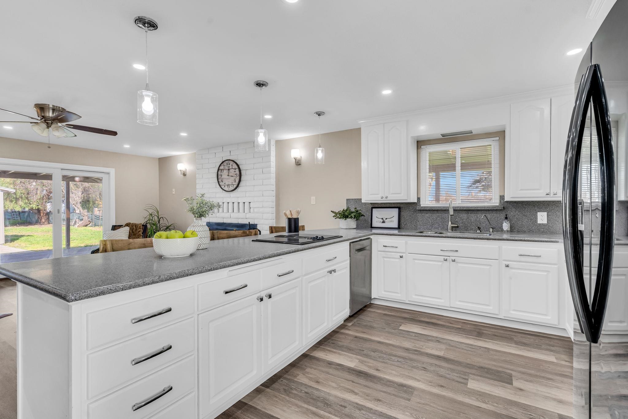 1660 Sunset Road Brentwood, CA 94513 - Photo 44 of 45 Kitchen featuring white cabinetry, black appliances, open floor plan, pendant lighting, and a ceiling fan